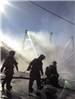 Fire fighters working with water hoses