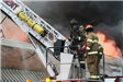Fire fighter wearing a mask prepares to climb the ladder