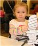Young girl showing the camera her Cat in the Hat craft