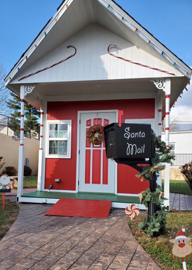 Black mailbox in front of Santa's House with words Santa's Mail on the side in white.