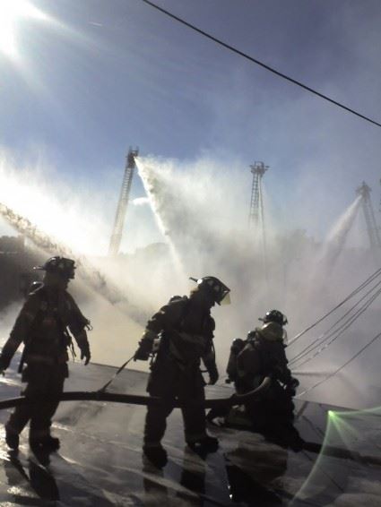 Fire fighters working with water hoses
