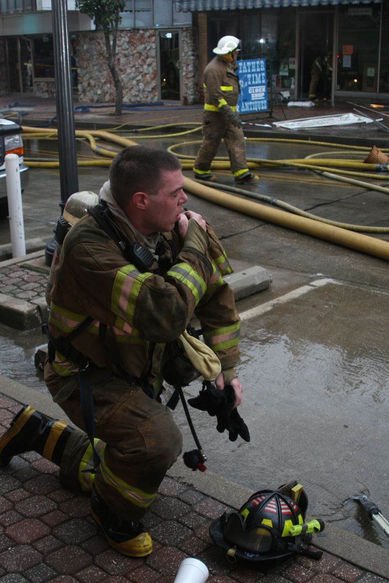 Fire fighter on a knee adjusting his gear