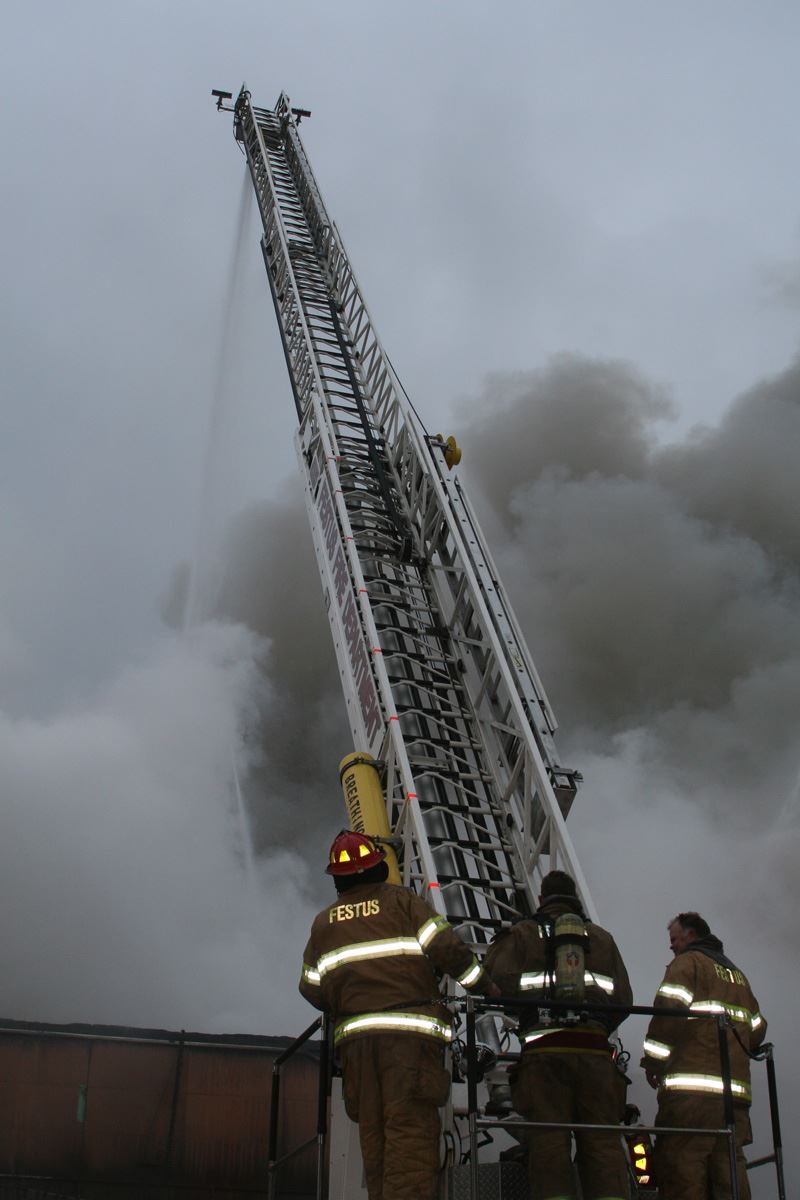 Fire fighters standing at the base of a ladder