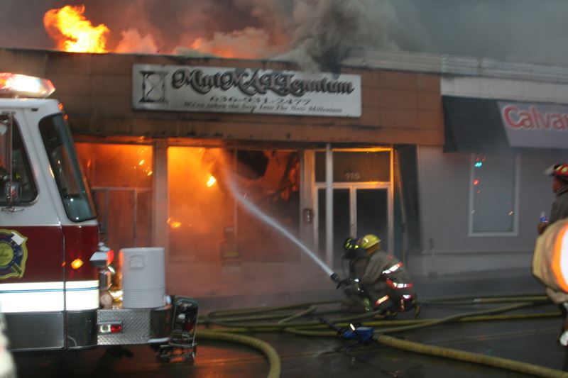 Fire fighter spraying a fire from the street