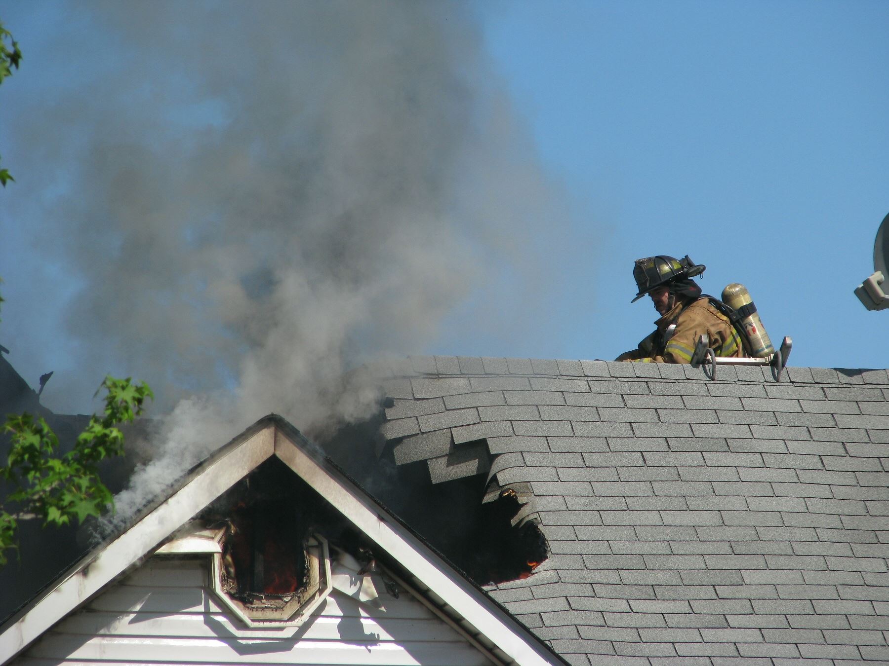Fire fighters on top of a house that was on fire