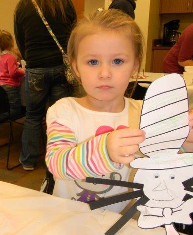 Young girl showing the camera her Cat in the Hat craft
