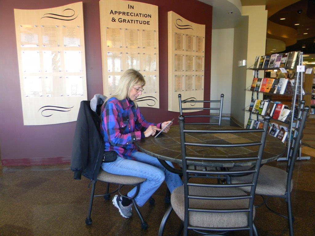 Woman sitting at a table with a tablet