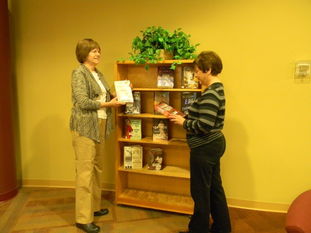 Two women looking at a bookshelf