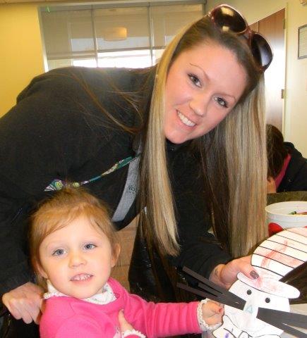 Lady and small girl showing the camera their craft