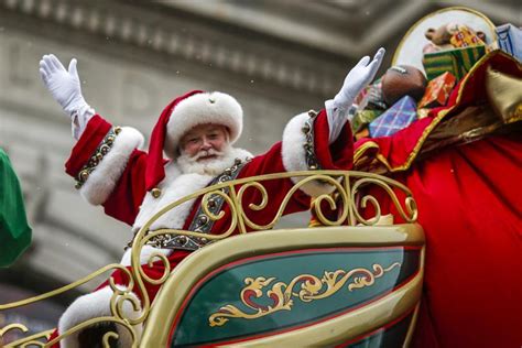 Santa, with a big smile,  in red sleigh with arms outstretched