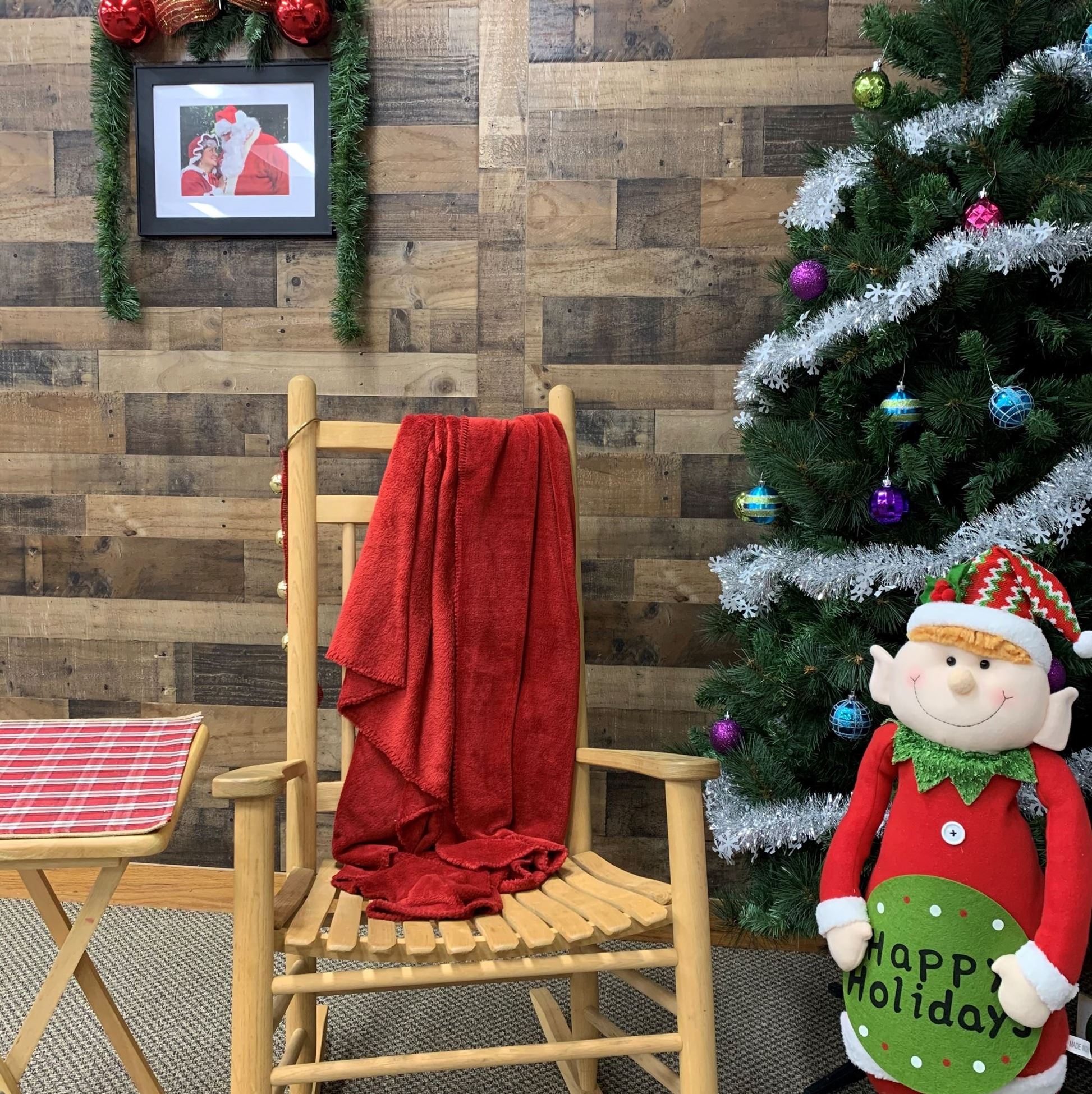 wooden rocking chair with red blanket next to Christmas tree